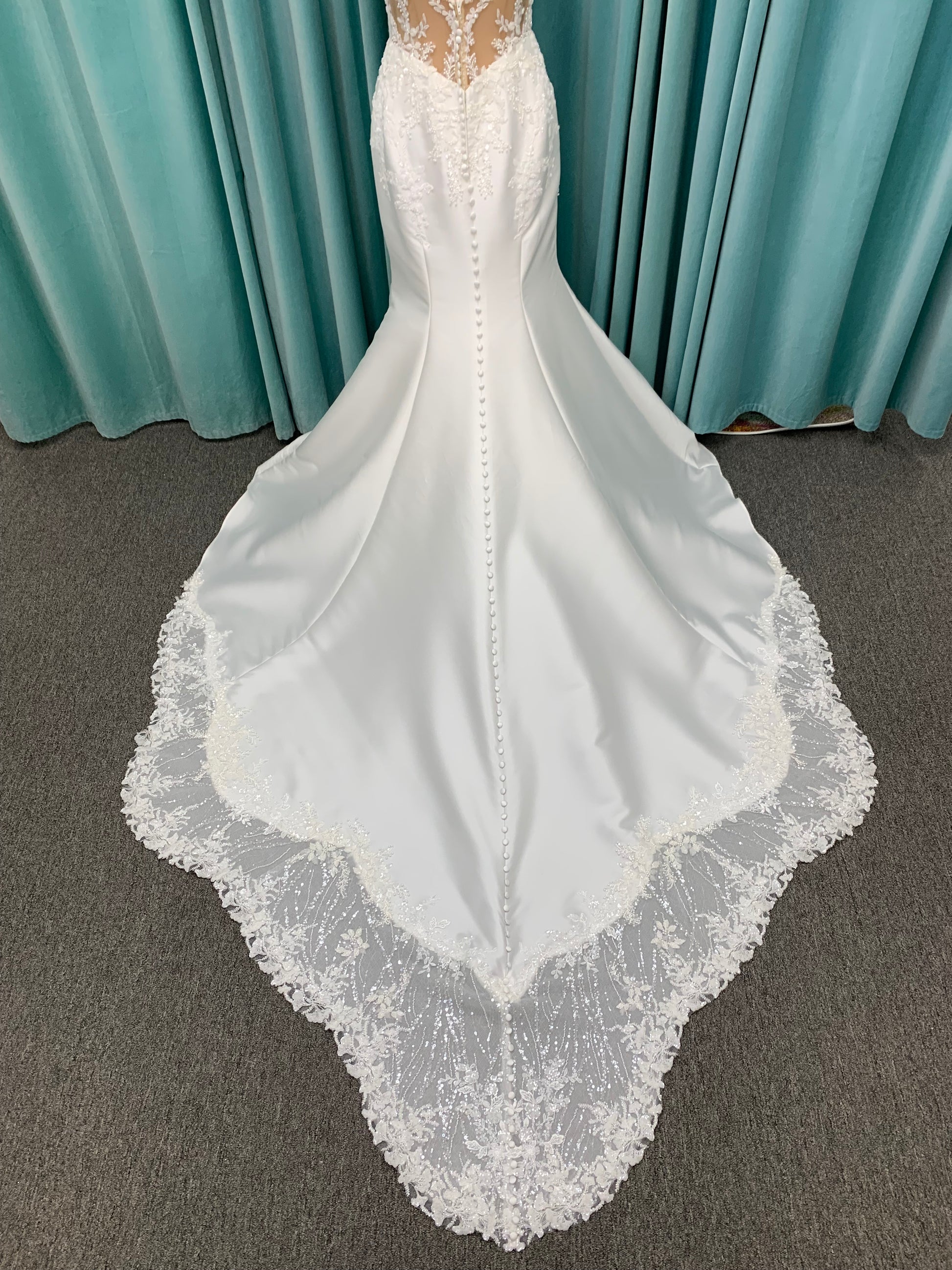 Marjorie ivory spaghetti strap wedding dress on mannequin with illusion corset bodice, floral lace appliqués, and scoop neckline.
