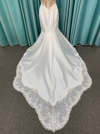 Marjorie ivory spaghetti strap wedding dress on mannequin with illusion corset bodice, floral lace appliqués, and scoop neckline.
