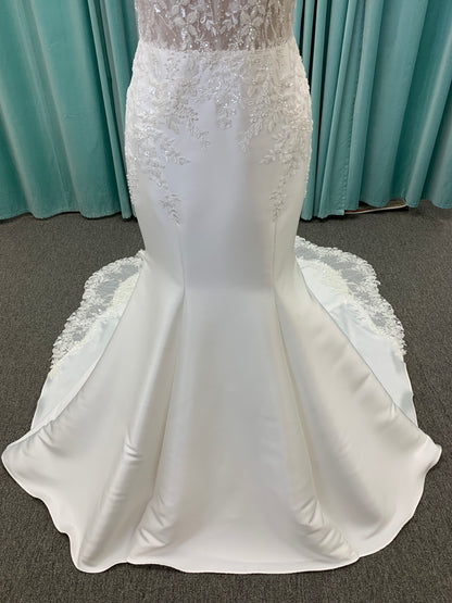 Marjorie ivory spaghetti strap wedding dress on mannequin with illusion corset bodice, floral lace appliqués, and scoop neckline.
