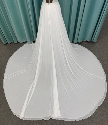 Martha My Dear ivory sleeveless V-neck A-line wedding dress on mannequin with geometric lace bodice panel and flowing chiffon skirt.
