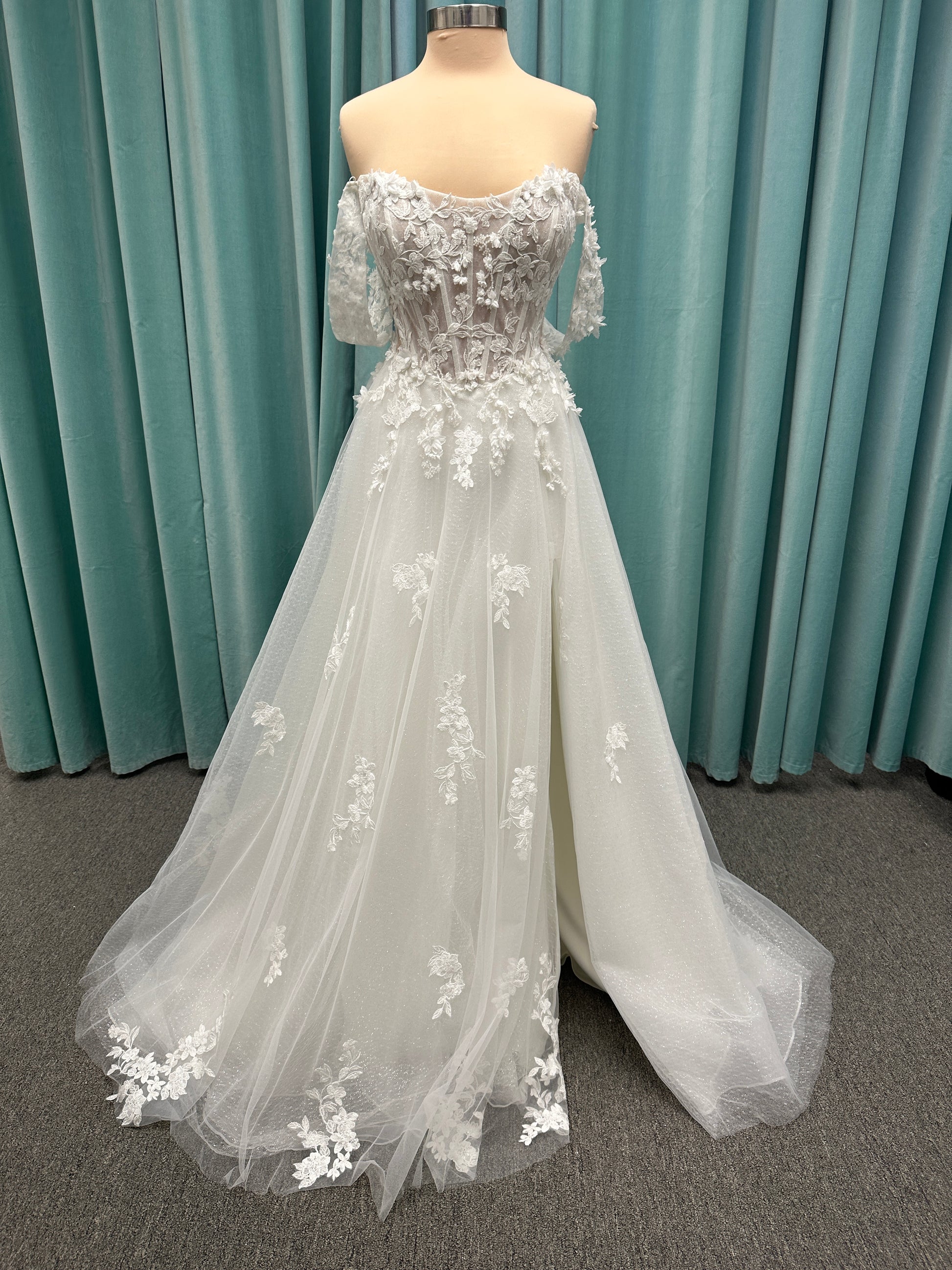 Off-the-shoulder lace A-line wedding dress with corset bodice, 3D floral appliqués, and glitter tulle skirt by Essense of Australia style D4360
