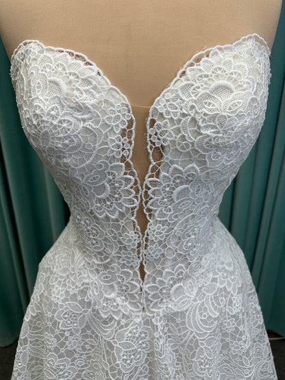 Min ivory strapless sweetheart lace A-line wedding dress on mannequin with illusion corset bodice and voluminous lace skirt.
