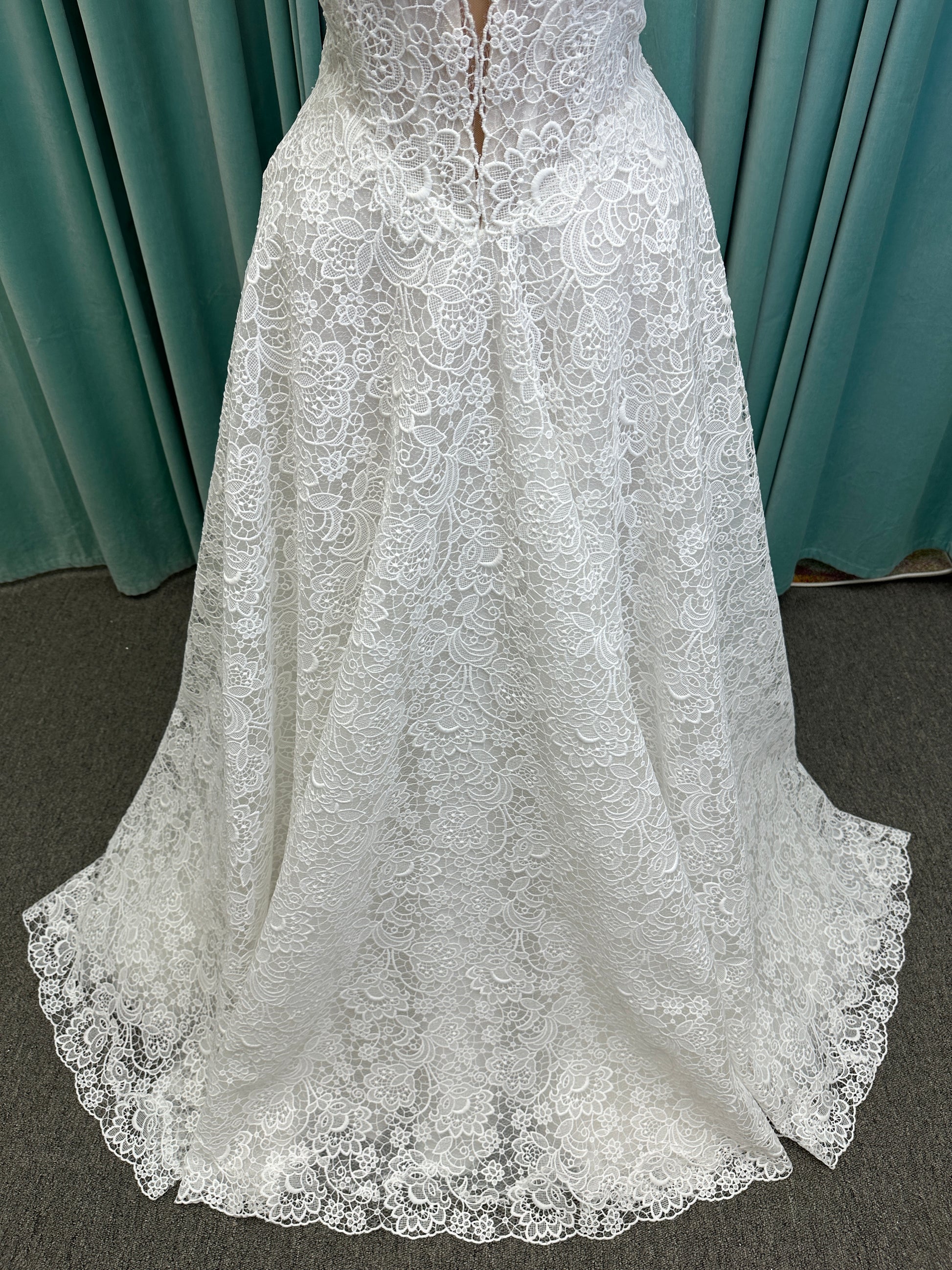 Min ivory strapless sweetheart lace A-line wedding dress on mannequin with illusion corset bodice and voluminous lace skirt.
