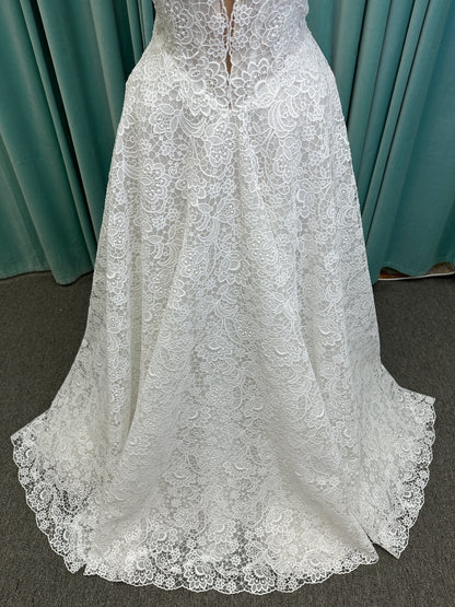 Min ivory strapless sweetheart lace A-line wedding dress on mannequin with illusion corset bodice and voluminous lace skirt.
