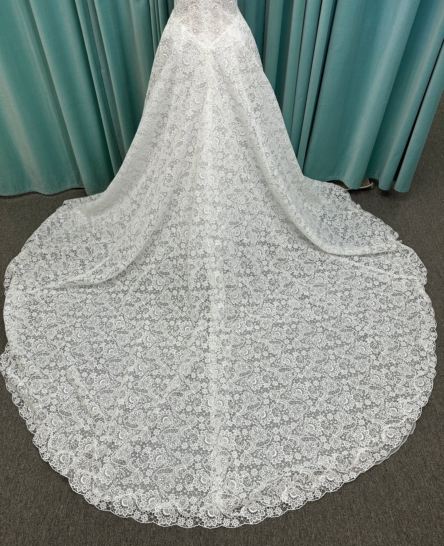 Min ivory strapless sweetheart lace A-line wedding dress on mannequin with illusion corset bodice and voluminous lace skirt.
