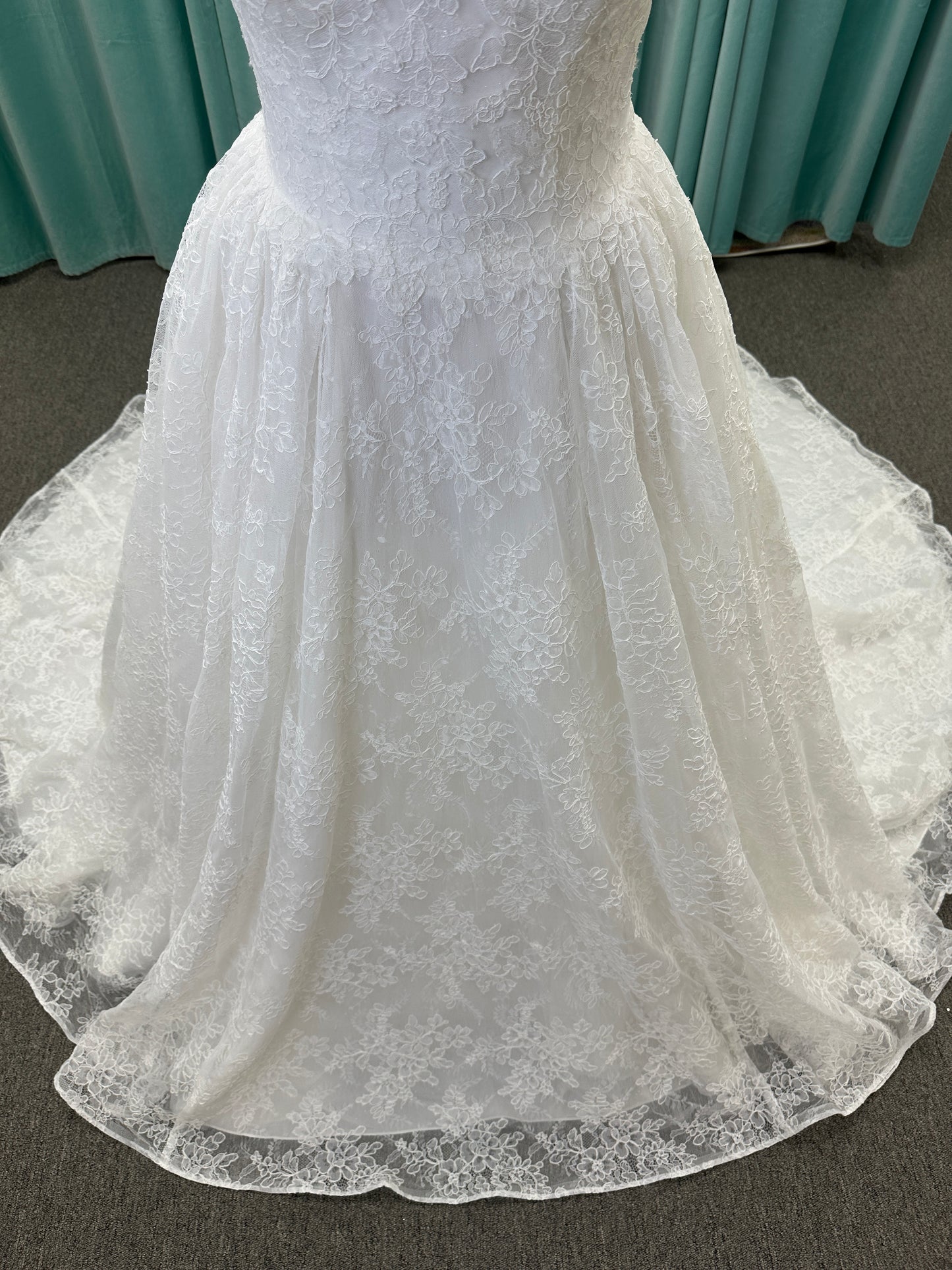 Moira ivory strapless sweetheart ballgown wedding dress on mannequin with sparkle lace detail and full voluminous skirt.
