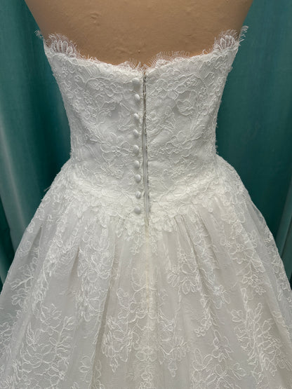 Moira ivory strapless sweetheart ballgown wedding dress on mannequin with sparkle lace detail and full voluminous skirt.
