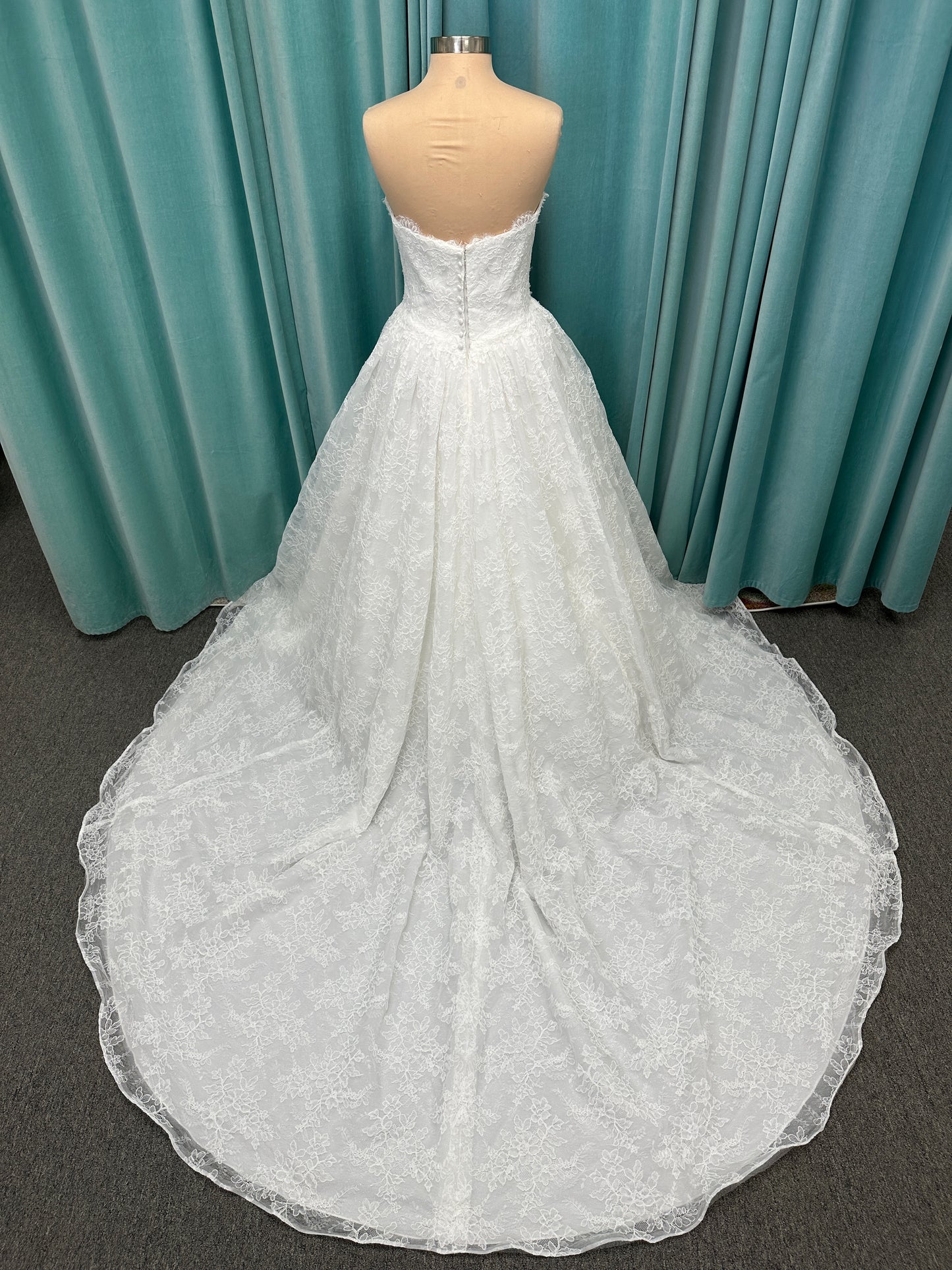 Moira ivory strapless sweetheart ballgown wedding dress on mannequin with sparkle lace detail and full voluminous skirt.
