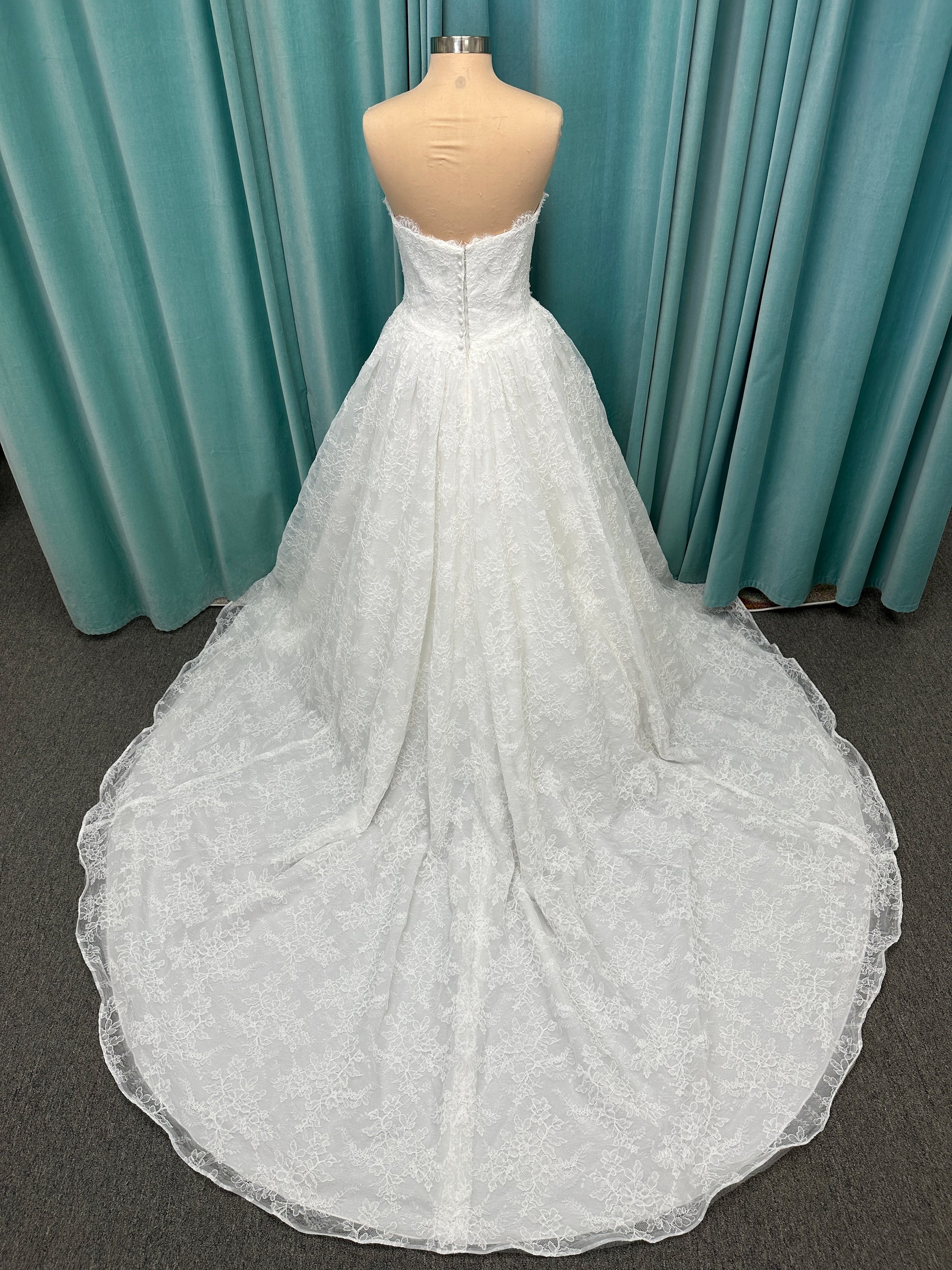 Moira ivory strapless sweetheart ballgown wedding dress on mannequin with sparkle lace detail and full voluminous skirt.
