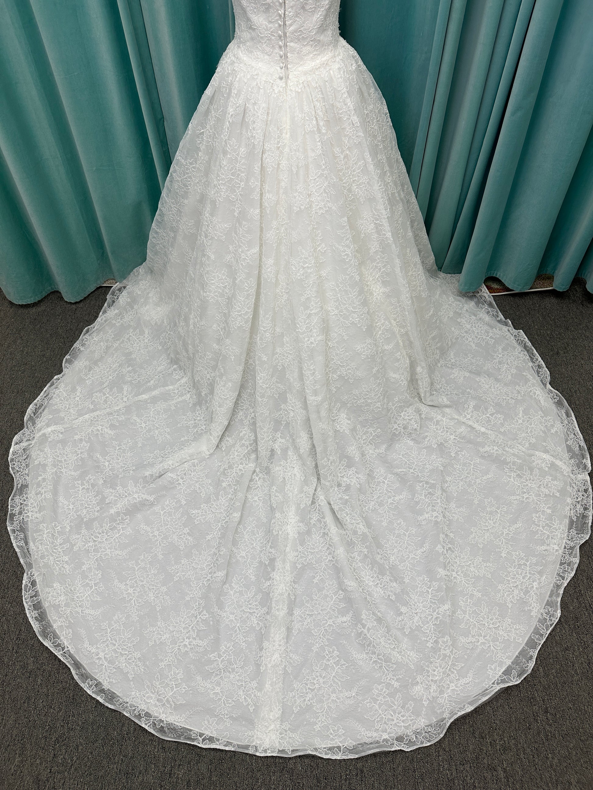 Moira ivory strapless sweetheart ballgown wedding dress on mannequin with sparkle lace detail and full voluminous skirt.
