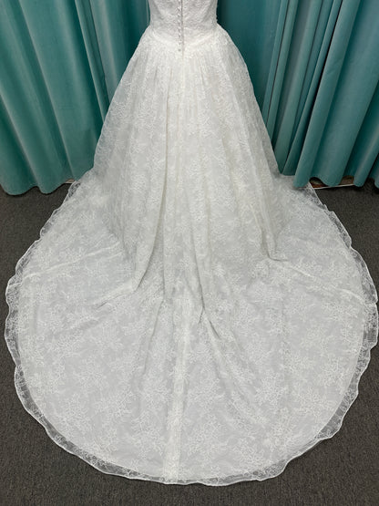 Moira ivory strapless sweetheart ballgown wedding dress on mannequin with sparkle lace detail and full voluminous skirt.
