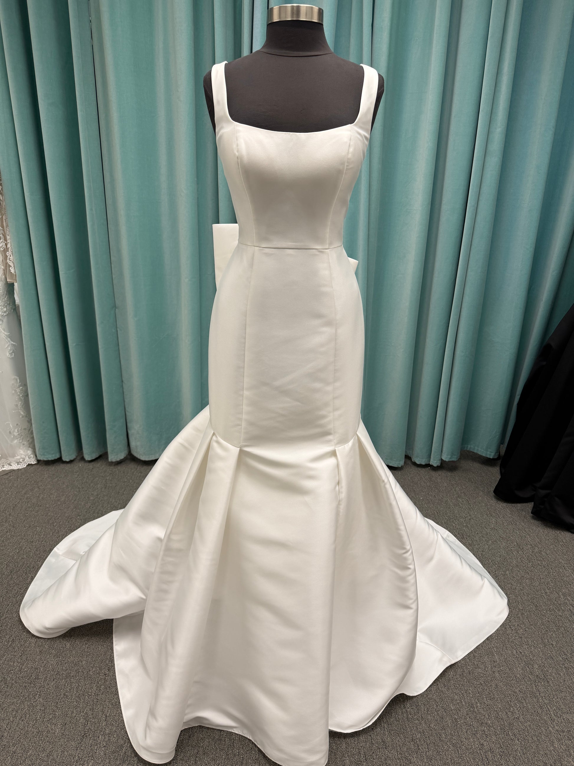 Modest Mikado fit-and-flare wedding dress with square neckline, low scoop back, and dramatic detachable bow train