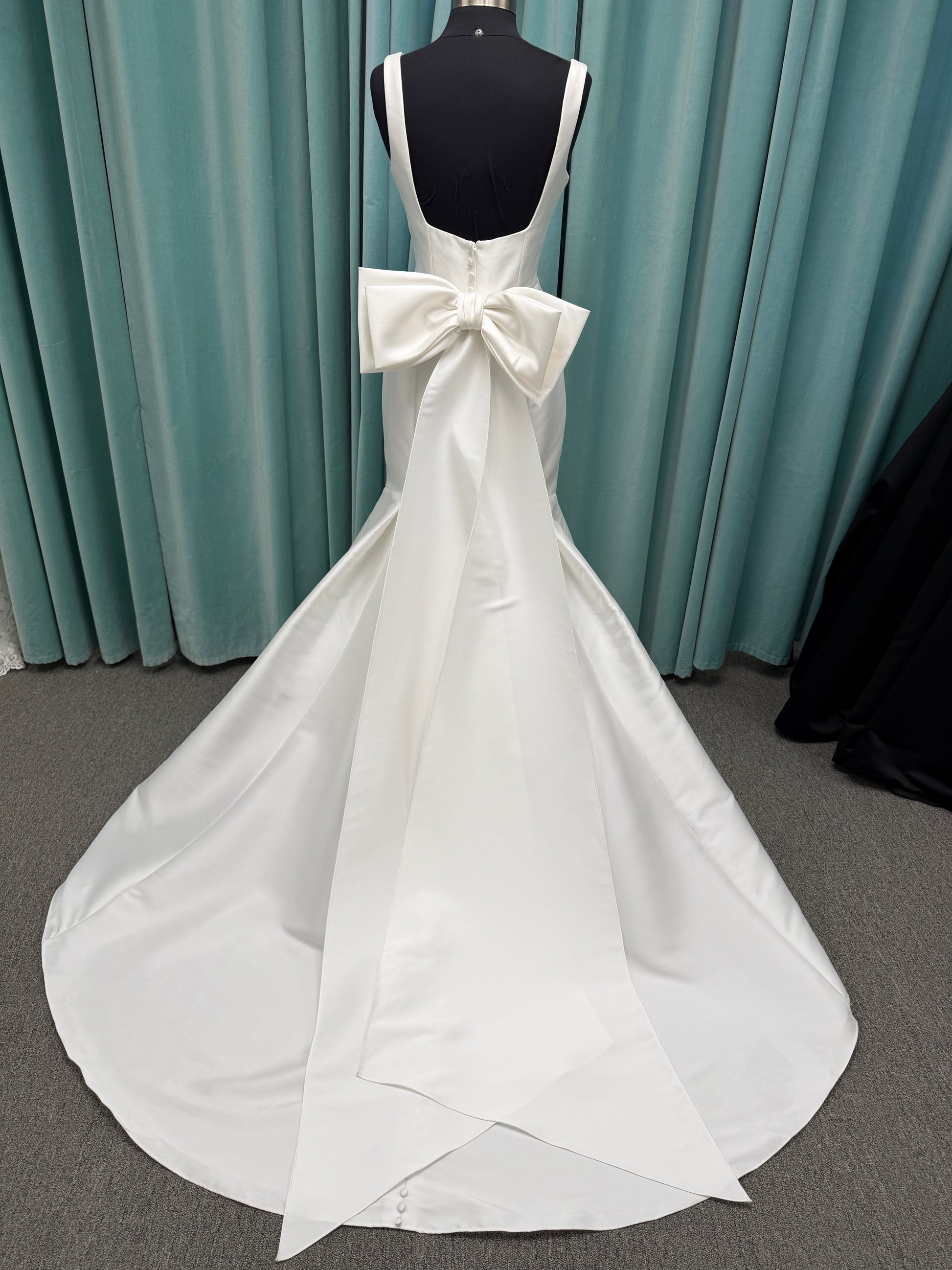 Modest Mikado fit-and-flare wedding dress with square neckline, low scoop back, and dramatic detachable bow train