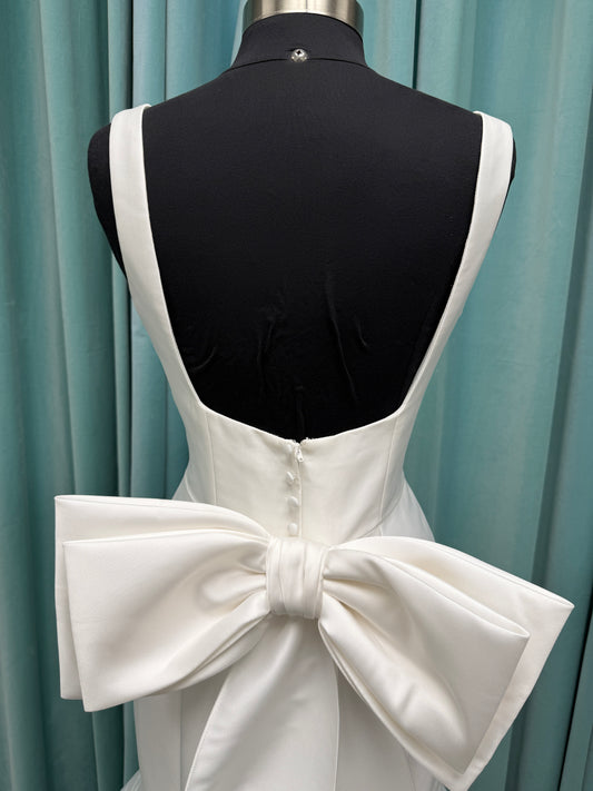 Modest Mikado fit-and-flare wedding dress with square neckline, low scoop back, and dramatic detachable bow train