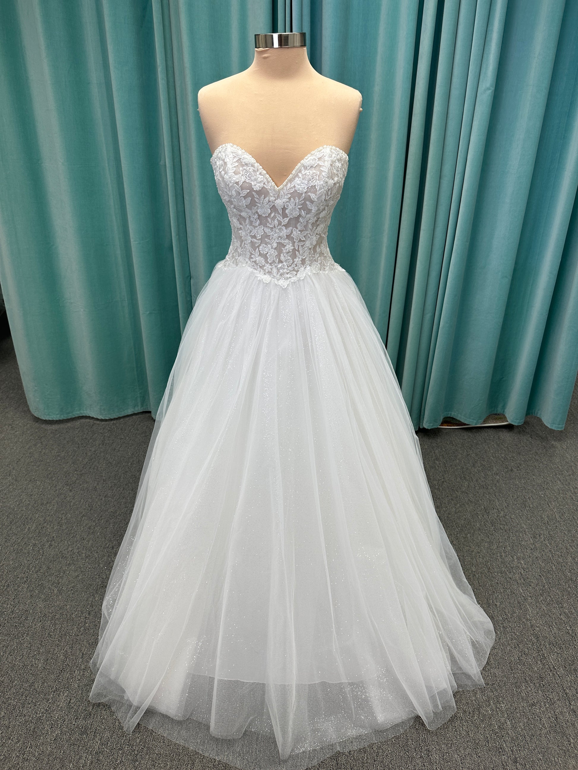 Paige ivory strapless sweetheart A-line wedding dress on mannequin with lace and tulle skirt.
