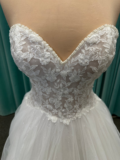Paige ivory strapless sweetheart A-line wedding dress on mannequin with lace and tulle skirt.
