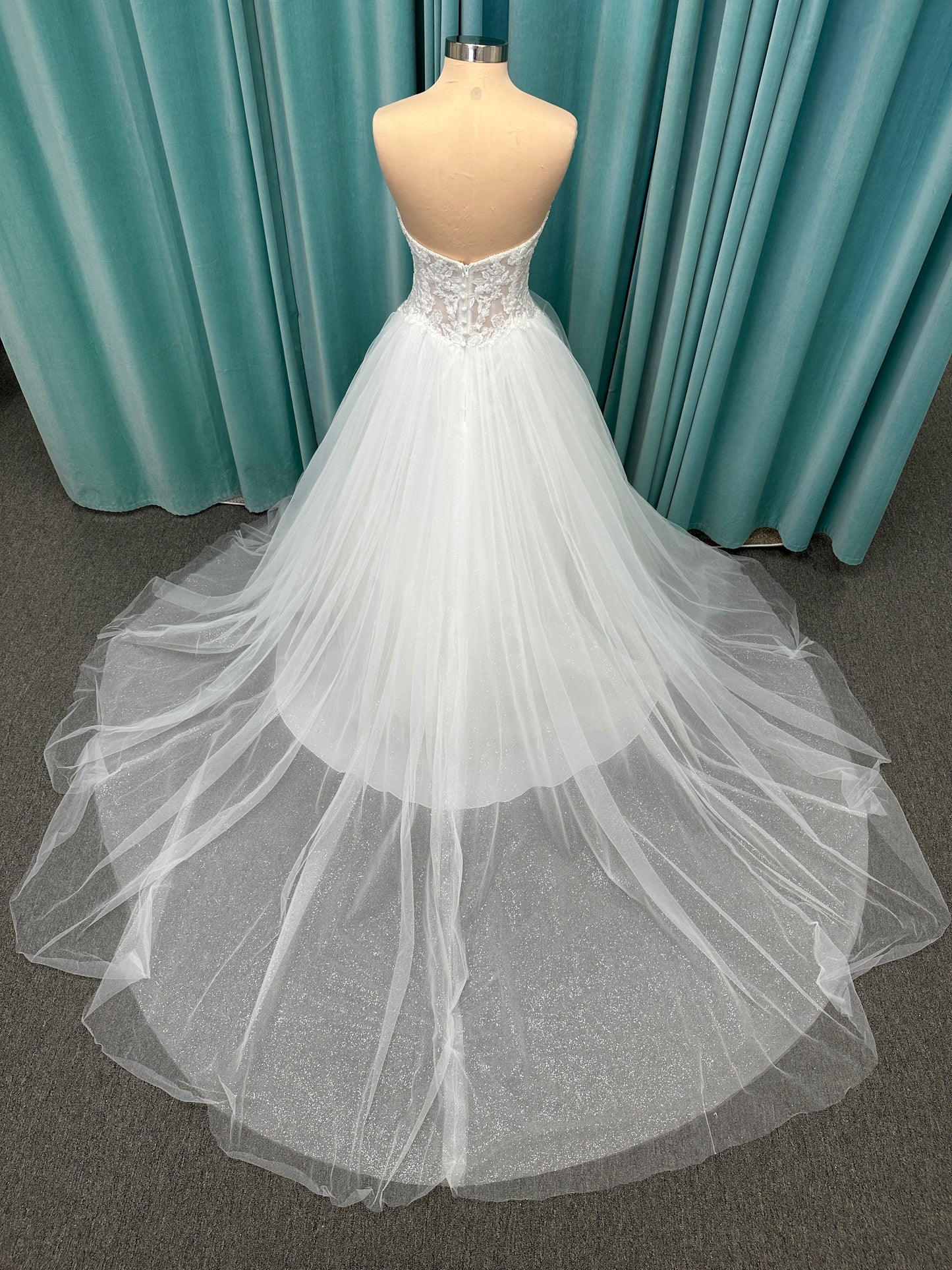 Paige ivory strapless sweetheart A-line wedding dress on mannequin with lace and tulle skirt.
