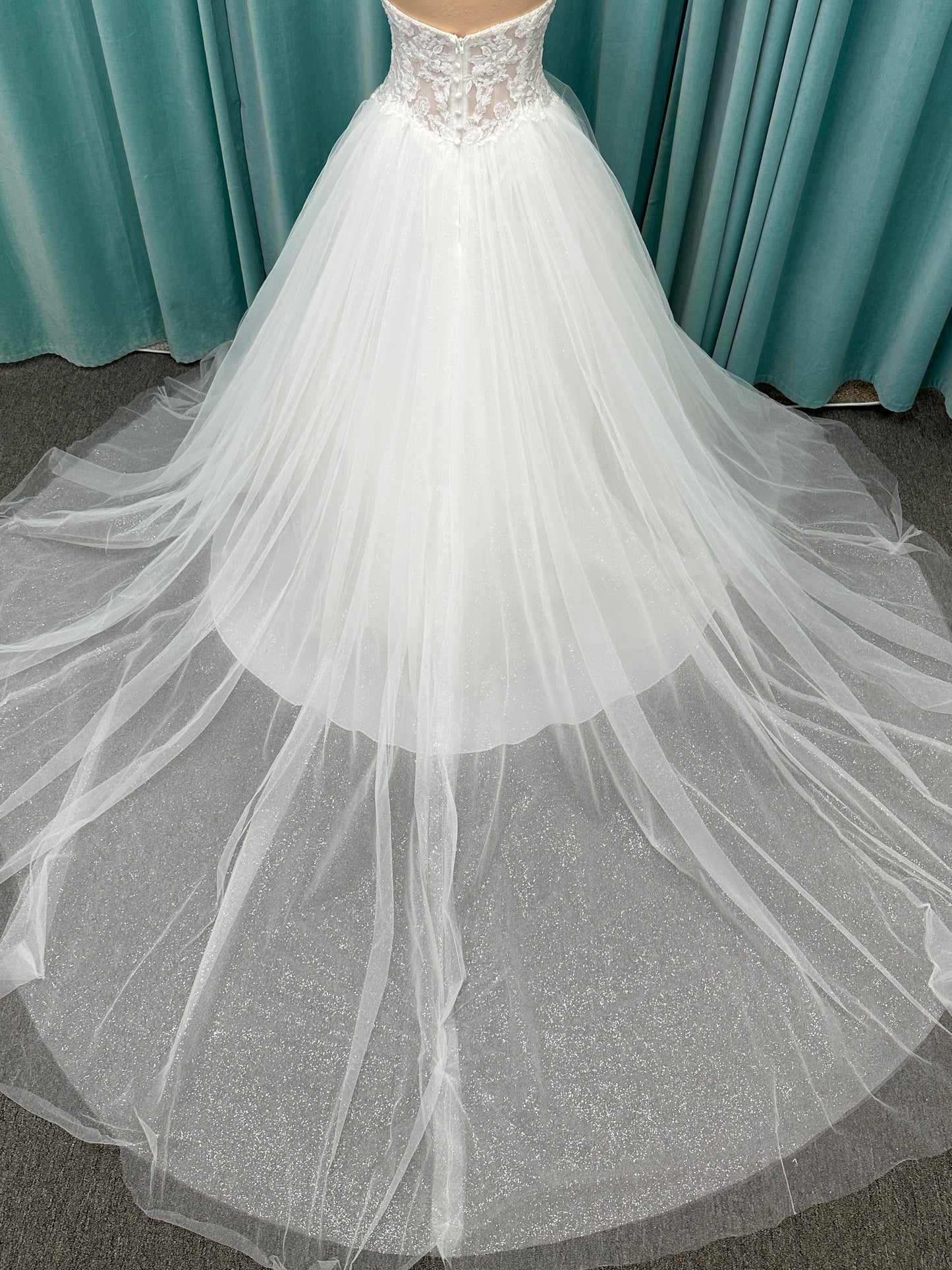Paige ivory strapless sweetheart A-line wedding dress on mannequin with lace and tulle skirt.

