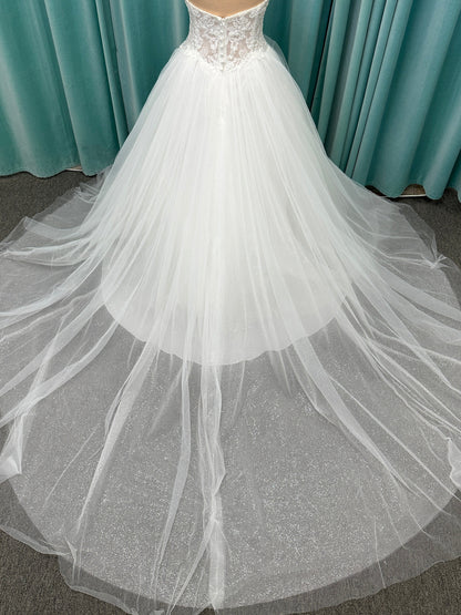 Paige ivory strapless sweetheart A-line wedding dress on mannequin with lace and tulle skirt.

