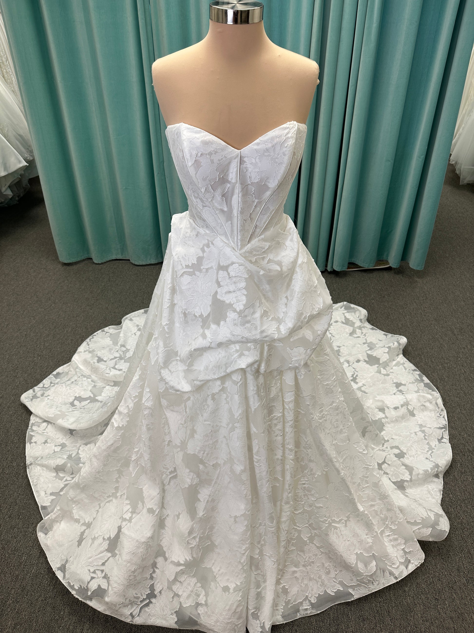Palmer ivory strapless sweetheart A-line wedding dress on mannequin in jacquard fabric with a front thigh-high slit.
