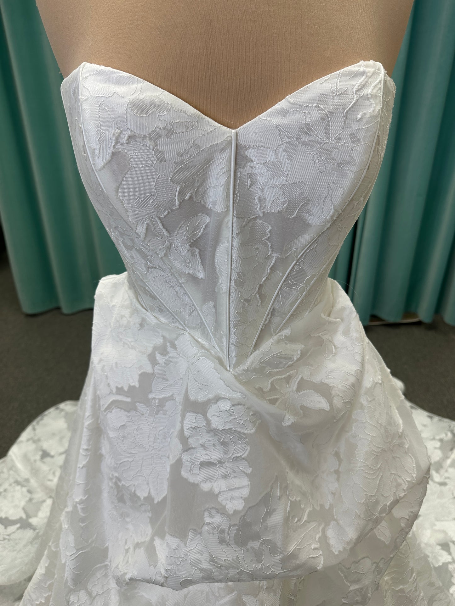 Palmer ivory strapless sweetheart A-line wedding dress on mannequin in jacquard fabric with a front thigh-high slit.
