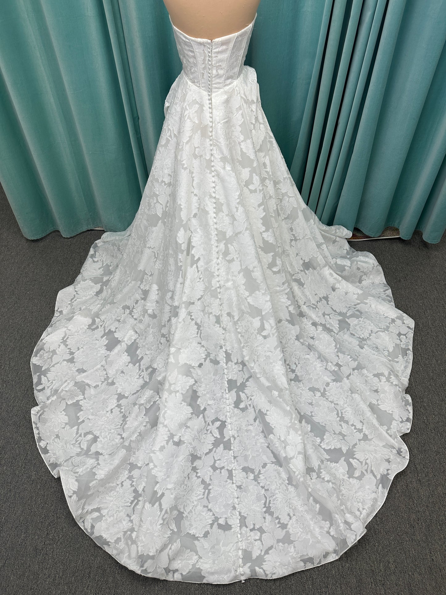 Palmer ivory strapless sweetheart A-line wedding dress on mannequin in jacquard fabric with a front thigh-high slit.
