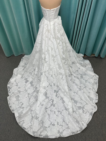 Palmer ivory strapless sweetheart A-line wedding dress on mannequin in jacquard fabric with a front thigh-high slit.
