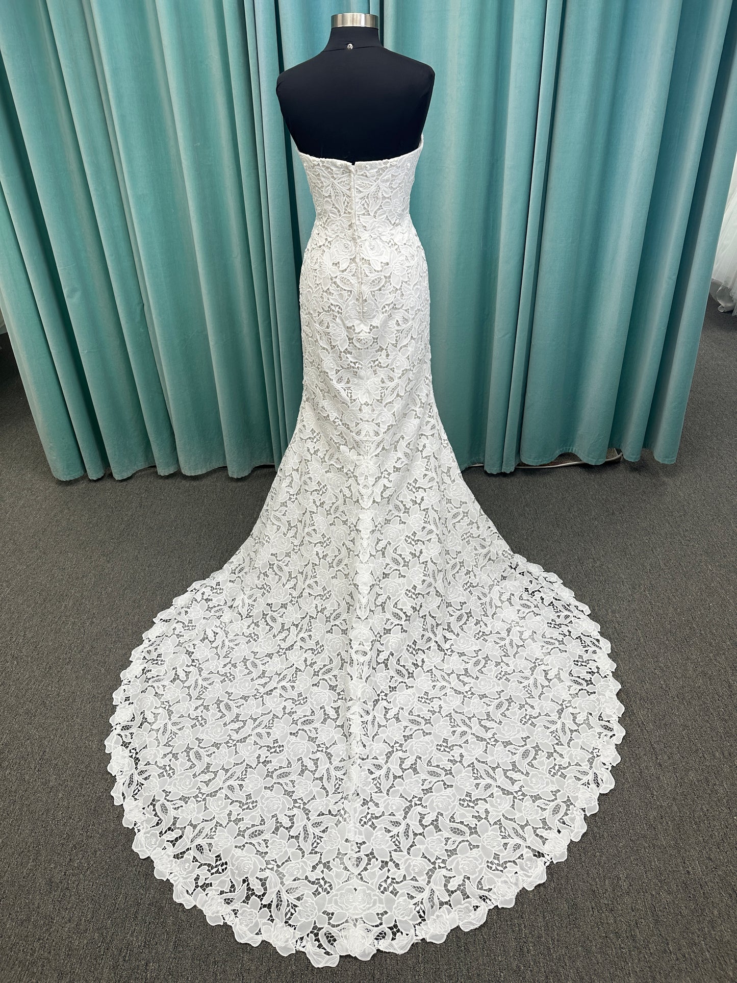 Patty ivory strapless sheath wedding dress on mannequin with sweetheart neckline and lace detail.
