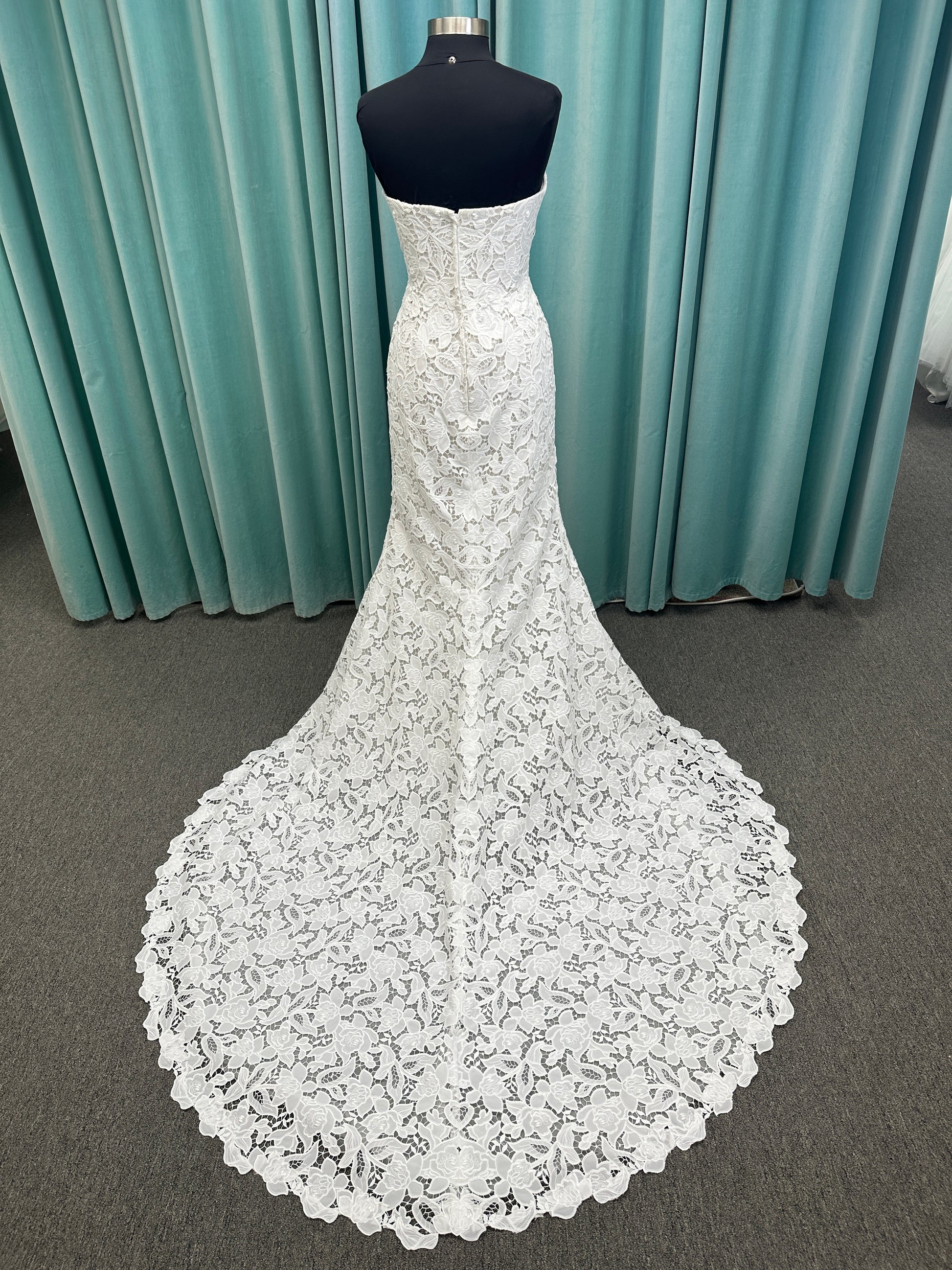 Patty ivory strapless sheath wedding dress on mannequin with sweetheart neckline and lace detail.
