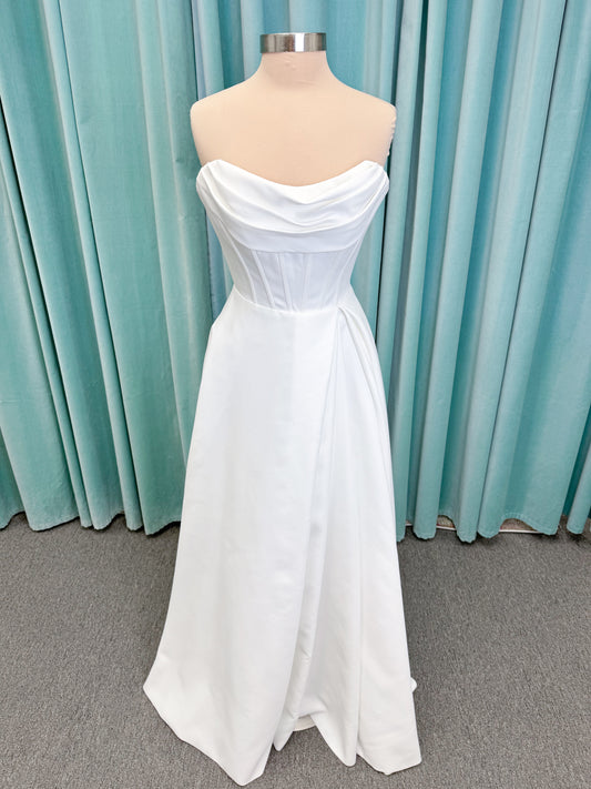 Morilee 15054 Pippa A-line wedding dress on mannequin with cowl neckline, corset bodice, petal satin skirt slit, and pockets