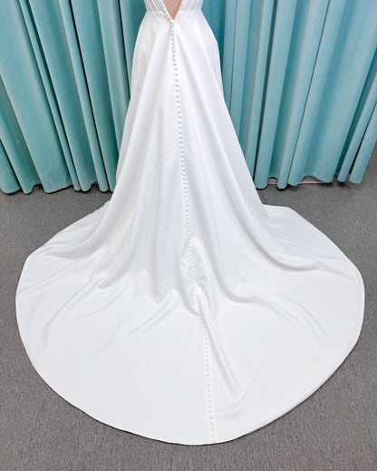 Morilee 15054 Pippa A-line wedding dress on mannequin with cowl neckline, corset bodice, petal satin skirt slit, and pockets