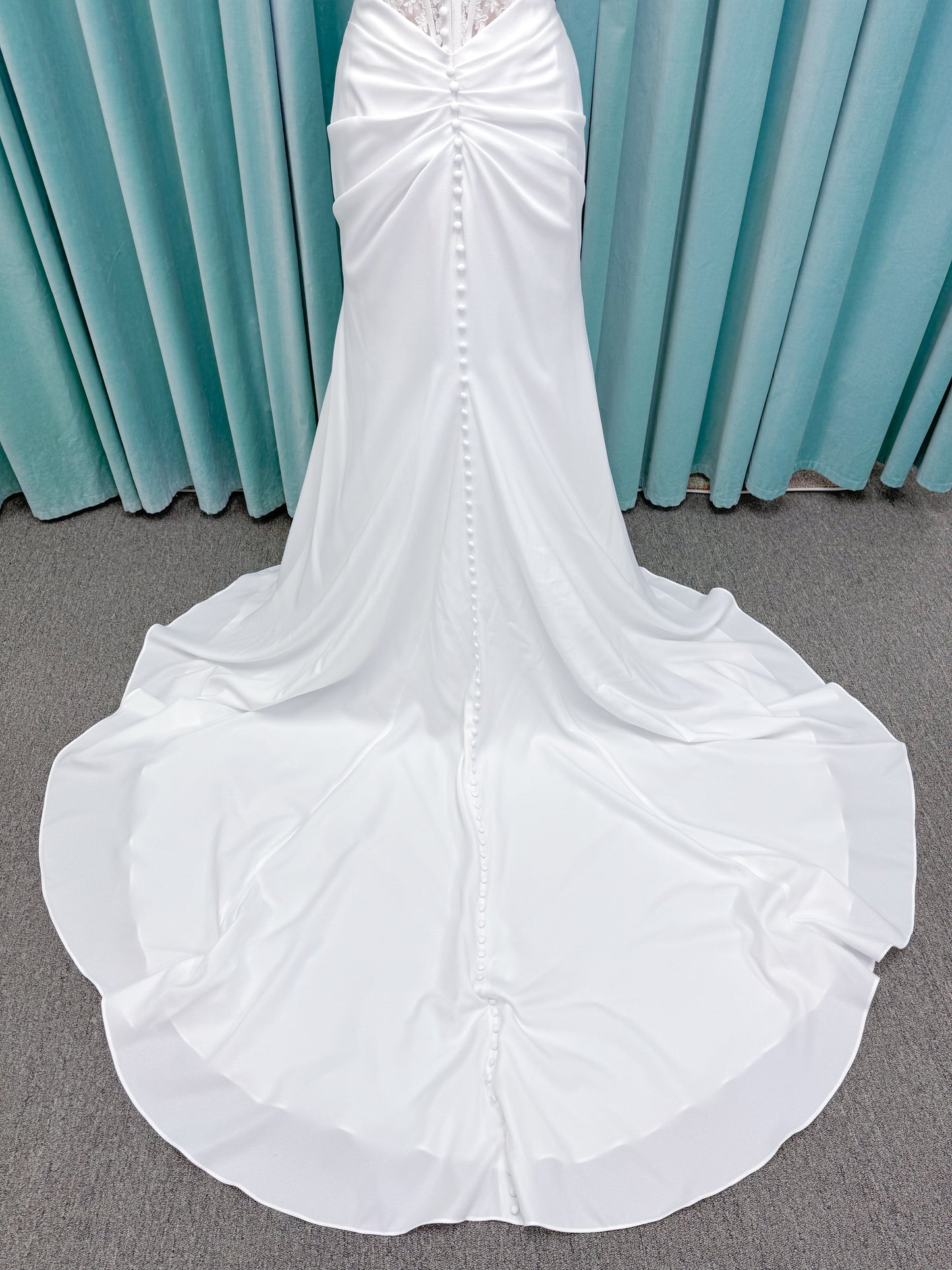 Morilee 1050008 Plie fit and flare wedding dress on mannequin with fluid draping and clean silhouette