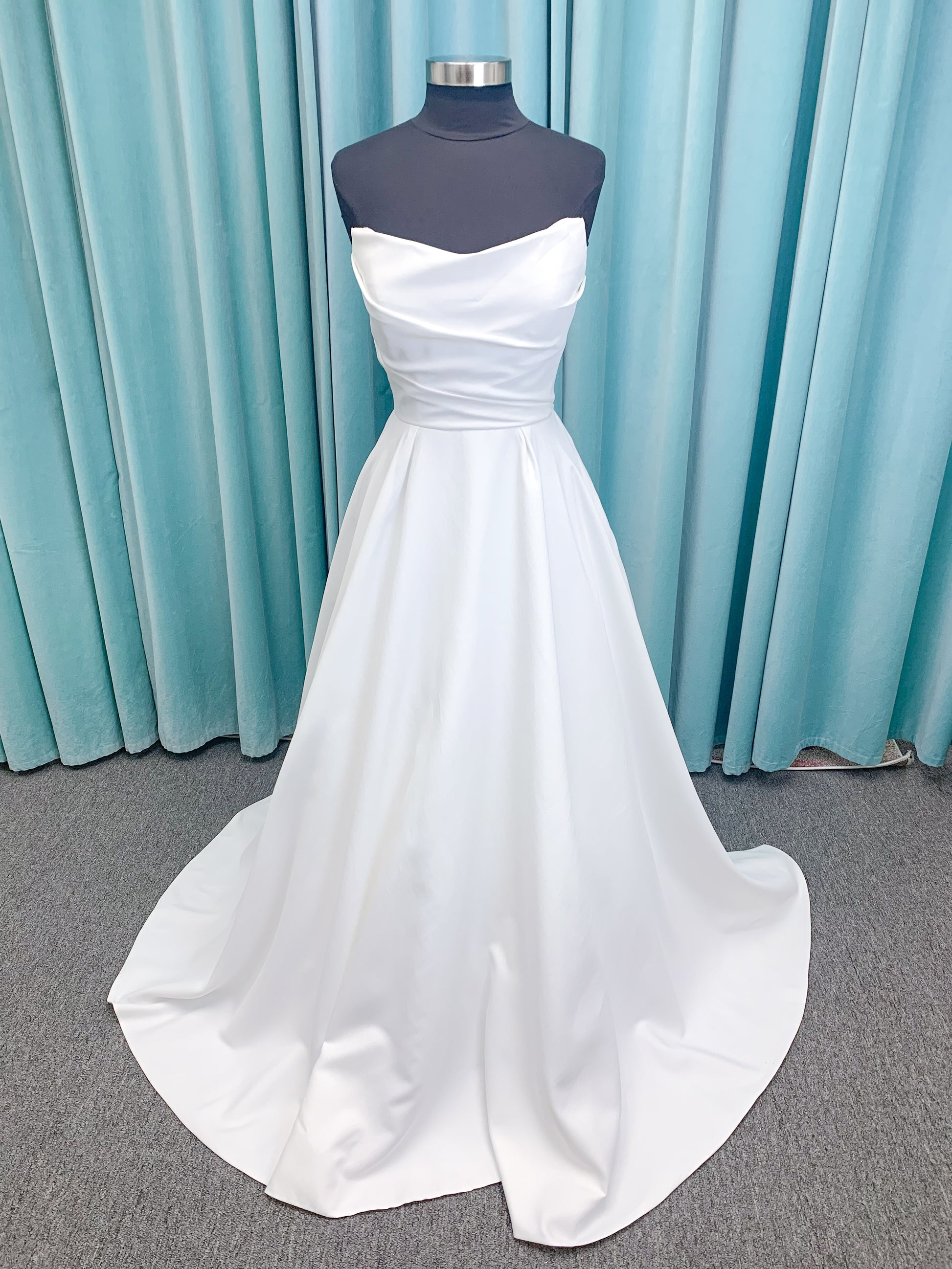 Morilee 4473 Reba A-line wedding dress in Larissa satin with cowl strapless neckline, detachable organza bow tie straps, and covered buttons to hem.