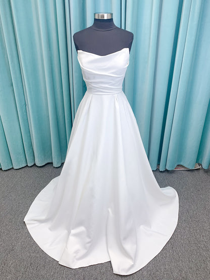 Morilee 4473 Reba A-line wedding dress in Larissa satin with cowl strapless neckline, detachable organza bow tie straps, and covered buttons to hem.