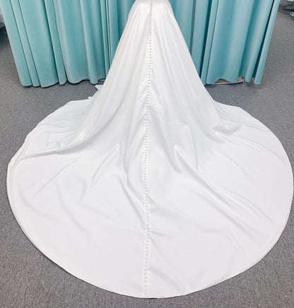 Morilee 4473 Reba A-line wedding dress in Larissa satin with cowl strapless neckline, detachable organza bow tie straps, and covered buttons to hem.