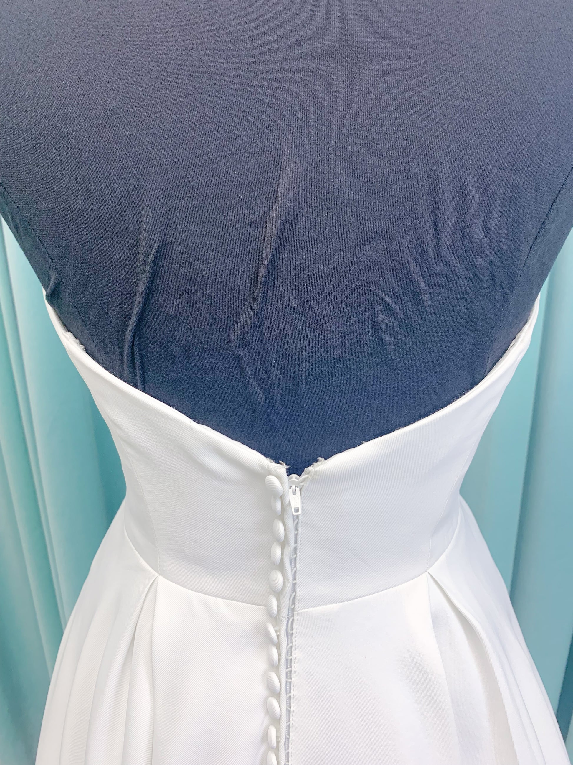 Morilee 4473 Reba A-line wedding dress in Larissa satin with cowl strapless neckline, detachable organza bow tie straps, and covered buttons to hem.
