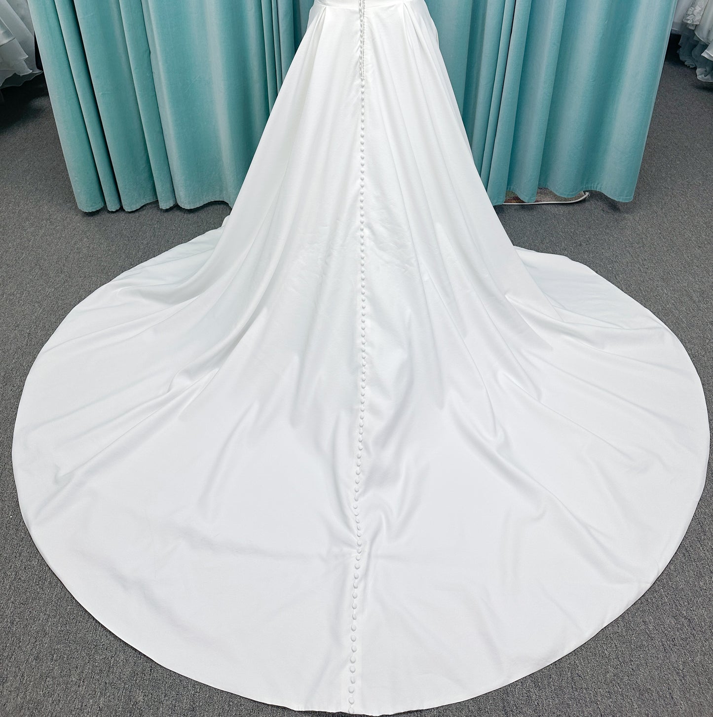 Morilee 4473 Reba plus size A-line wedding dress in Larissa satin with cowl strapless neck, detachable organza bow tie straps, and covered buttons to hem.