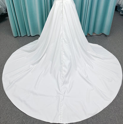 Morilee 4473 Reba plus size A-line wedding dress in Larissa satin with cowl strapless neck, detachable organza bow tie straps, and covered buttons to hem.