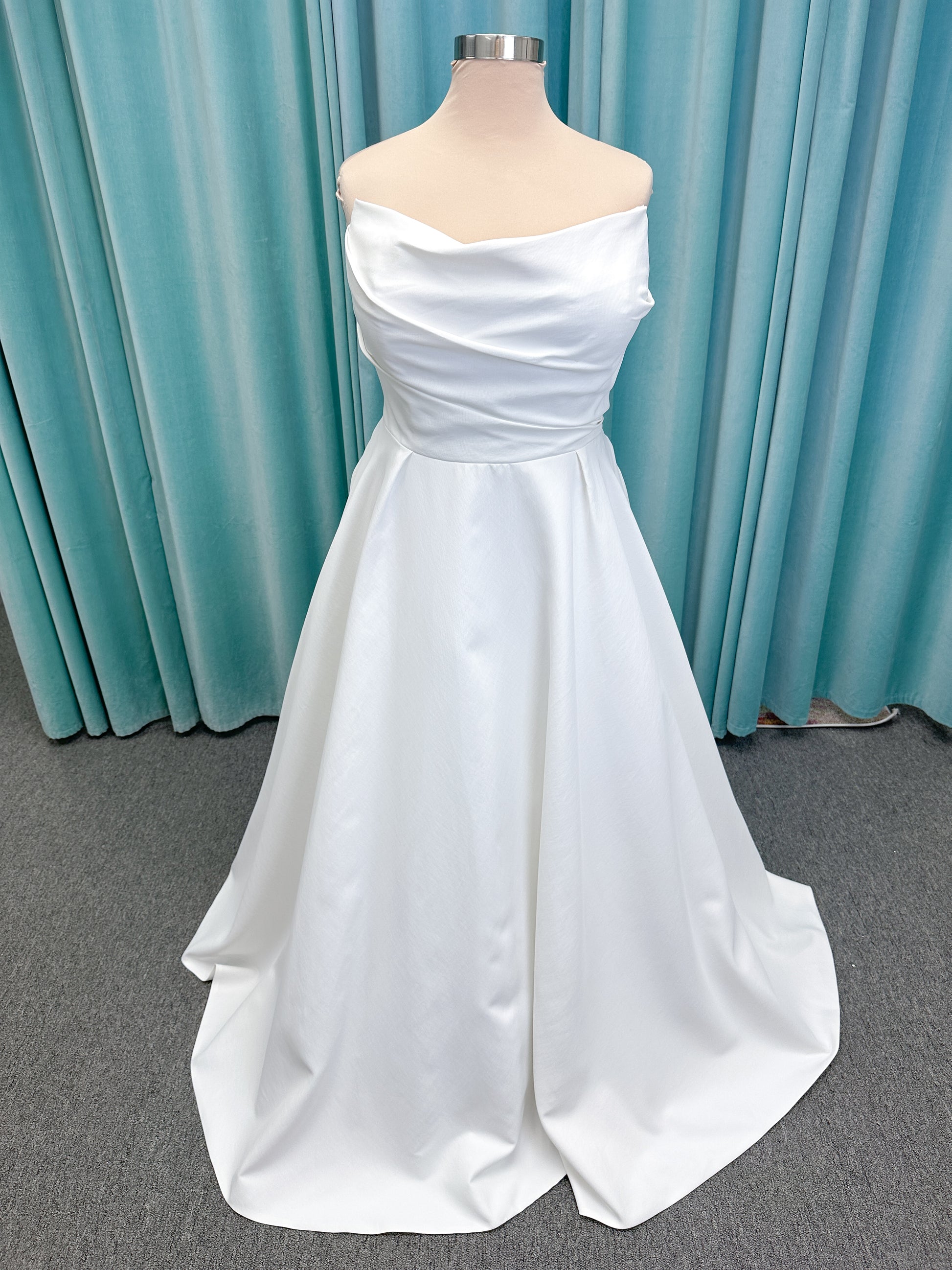 Morilee 4473 Reba plus size A-line wedding dress in Larissa satin with cowl strapless neck, detachable organza bow tie straps, and covered buttons to hem.