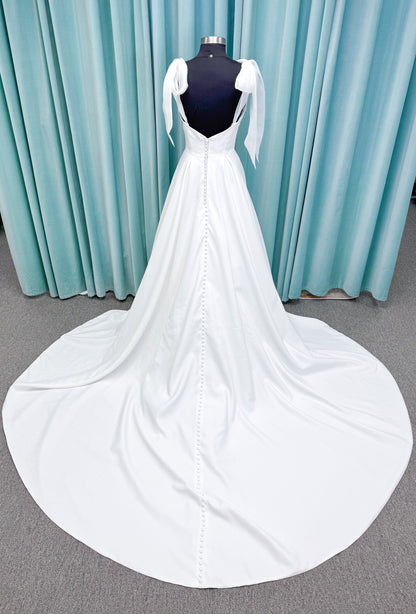 Morilee 4473 Reba A-line wedding dress in Larissa satin with cowl strapless neckline, detachable organza bow tie straps, and covered buttons to hem.