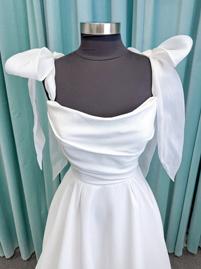 Morilee 4473 Reba A-line wedding dress in Larissa satin with cowl strapless neckline, detachable organza bow tie straps, and covered buttons to hem.