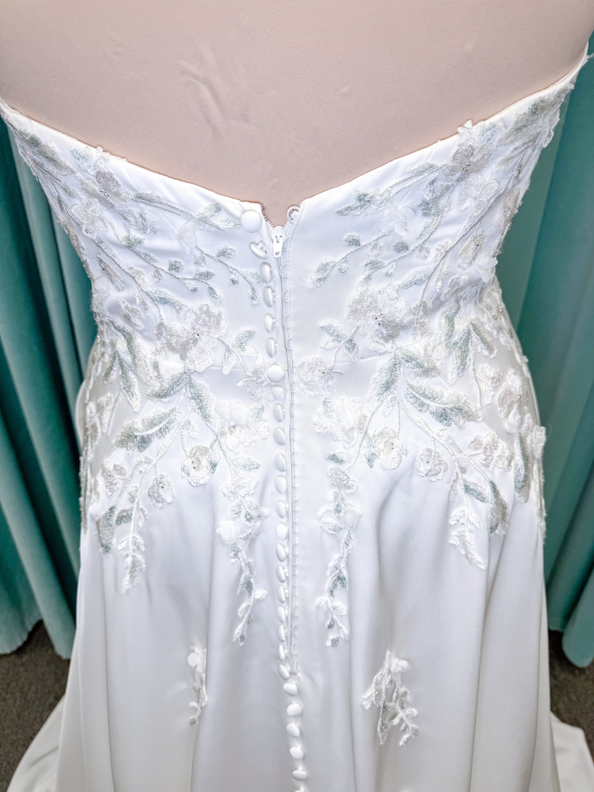 Morilee 4471 Roberta plus size wedding dress on mannequin with angular strapless neckline, 3D floral beaded embroidery, and satin A-line skirt