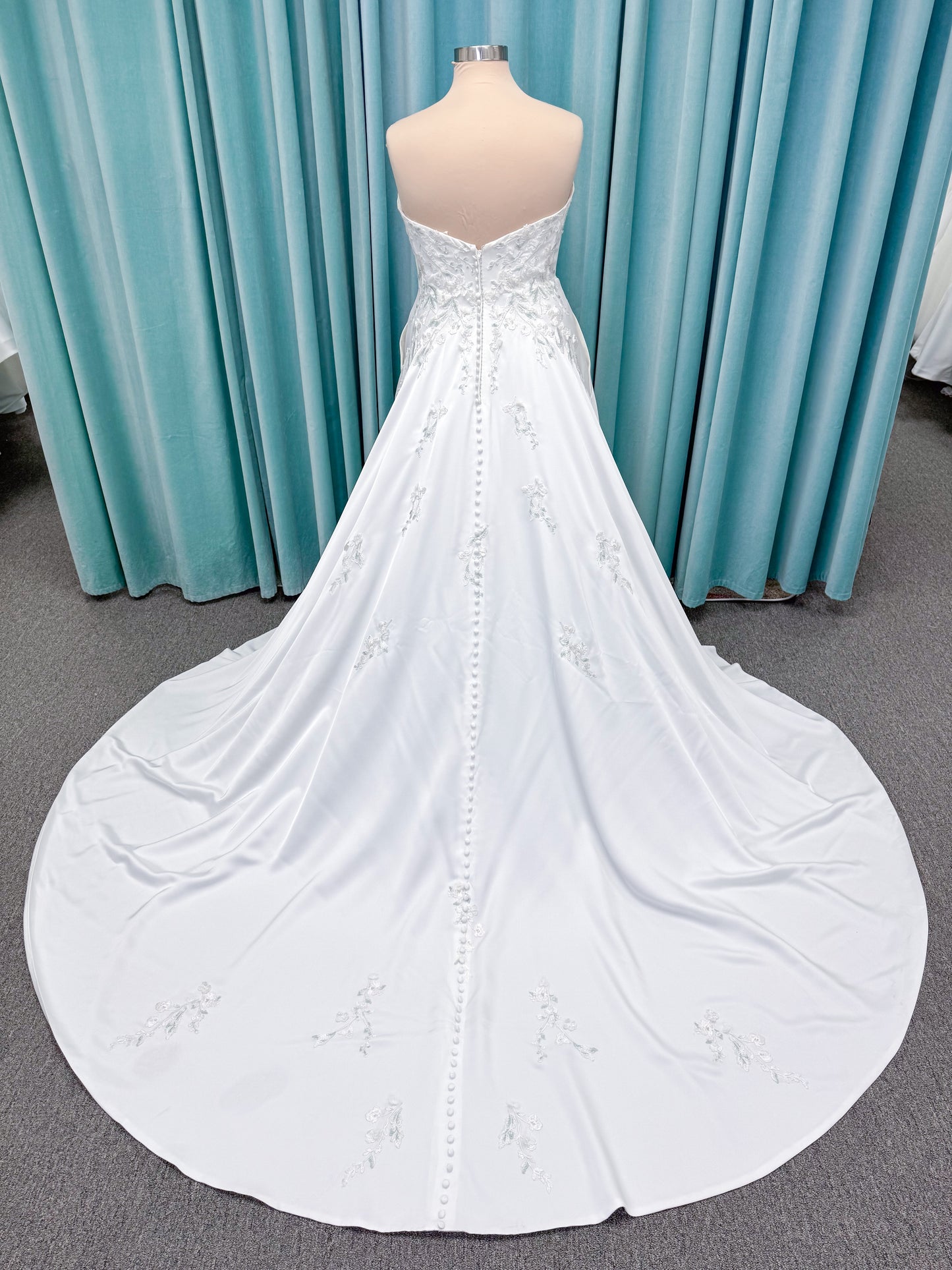 Morilee 4471 Roberta plus size wedding dress on mannequin with angular strapless neckline, 3D floral beaded embroidery, and satin A-line skirt