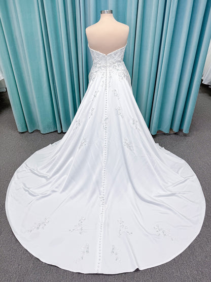Morilee 4471 Roberta plus size wedding dress on mannequin with angular strapless neckline, 3D floral beaded embroidery, and satin A-line skirt