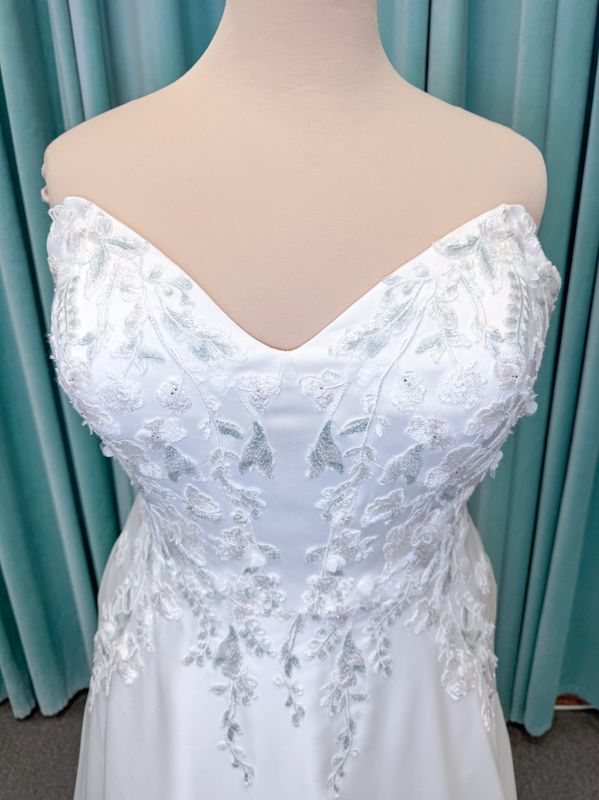 Morilee 4471 Roberta plus size wedding dress on mannequin with angular strapless neckline, 3D floral beaded embroidery, and satin A-line skirt