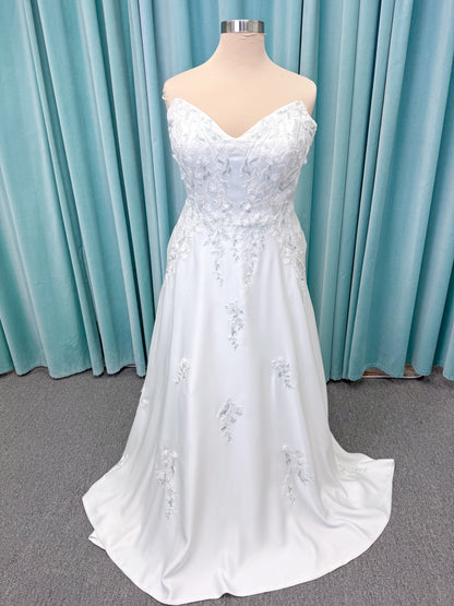 Morilee 4471 Roberta plus size wedding dress on mannequin with angular strapless neckline, 3D floral beaded embroidery, and satin A-line skirt