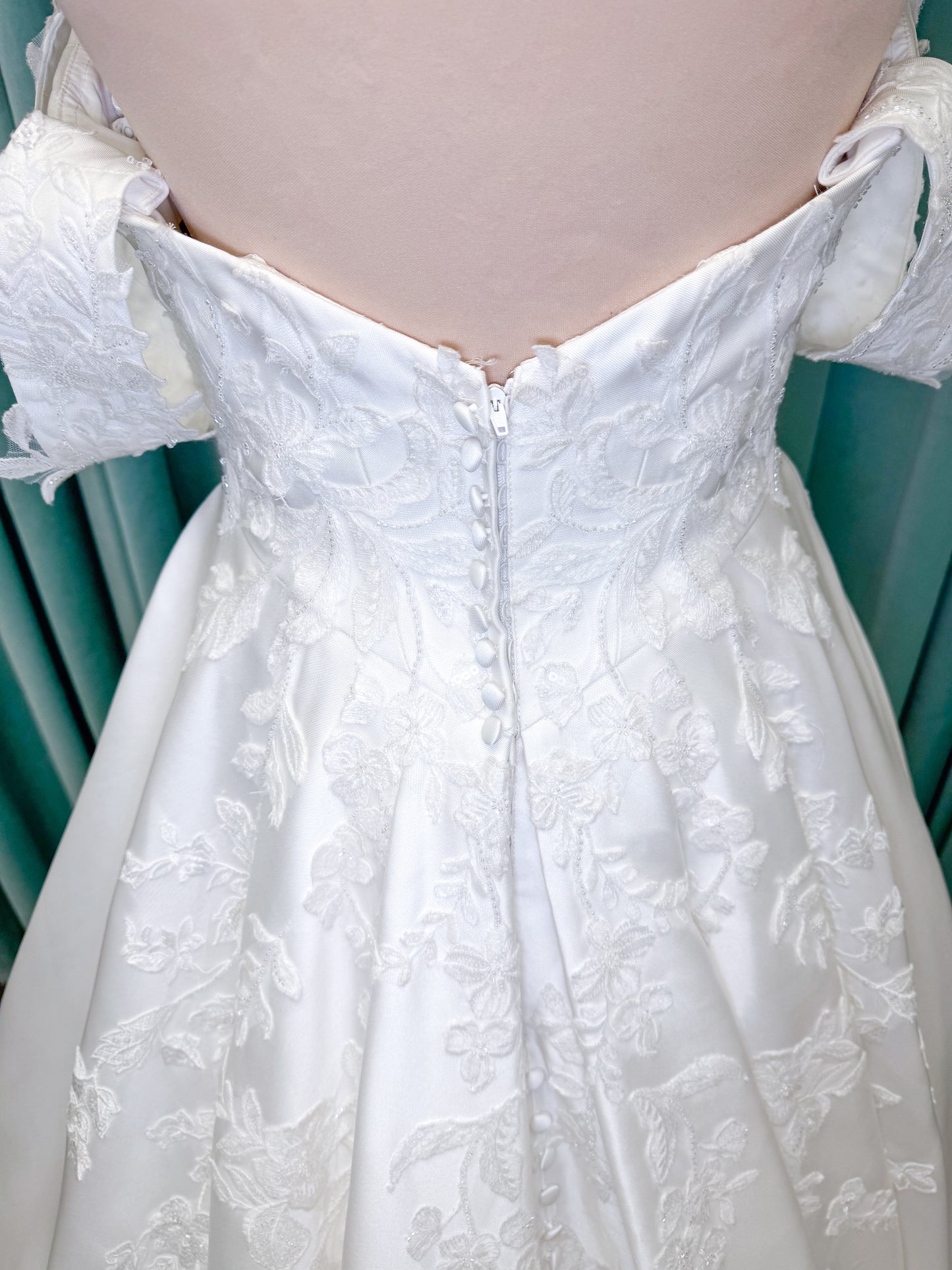 Morilee 2643 Rosemarie A-line wedding dress on mannequin with sweetheart plunging neckline, long sleeves, and frosted embroidered lace appliques