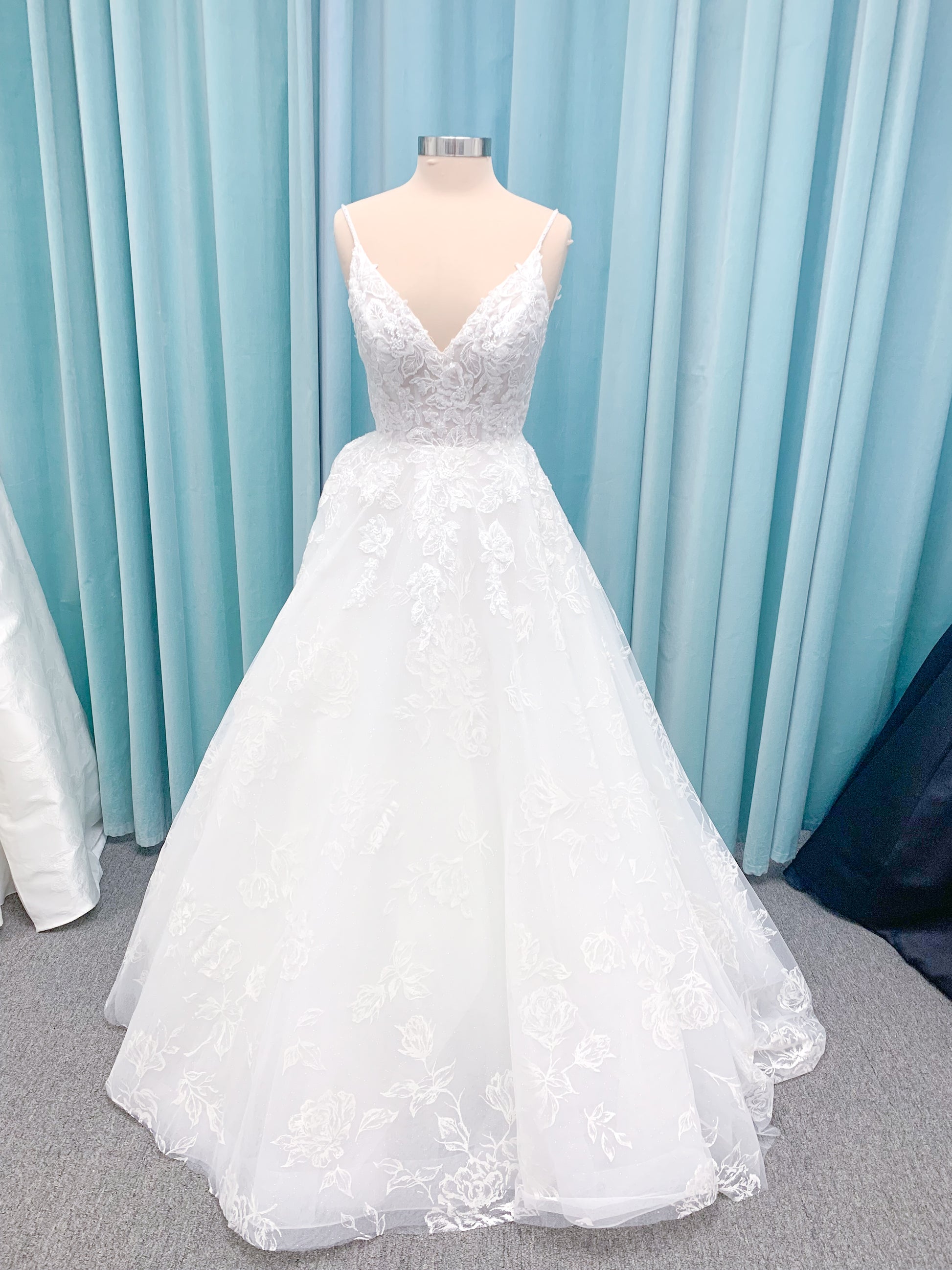 Morilee 2988 Rosie ball gown wedding dress in rose-printed organza over glitter tulle with V-neck, thin straps, structured boning, and voluminous sweeping train.