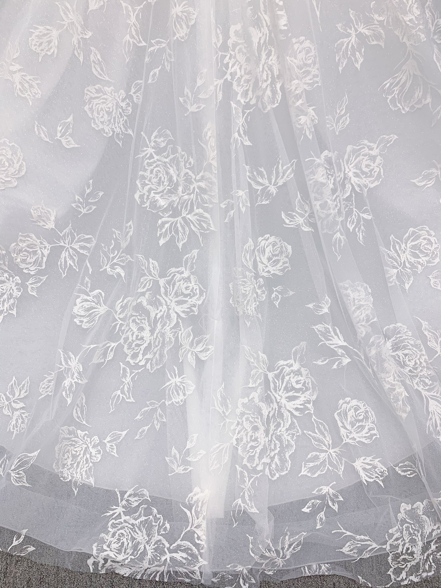 Morilee 2988 Rosie ball gown wedding dress in rose-printed organza over glitter tulle with V-neck, thin straps, structured boning, and voluminous sweeping train.