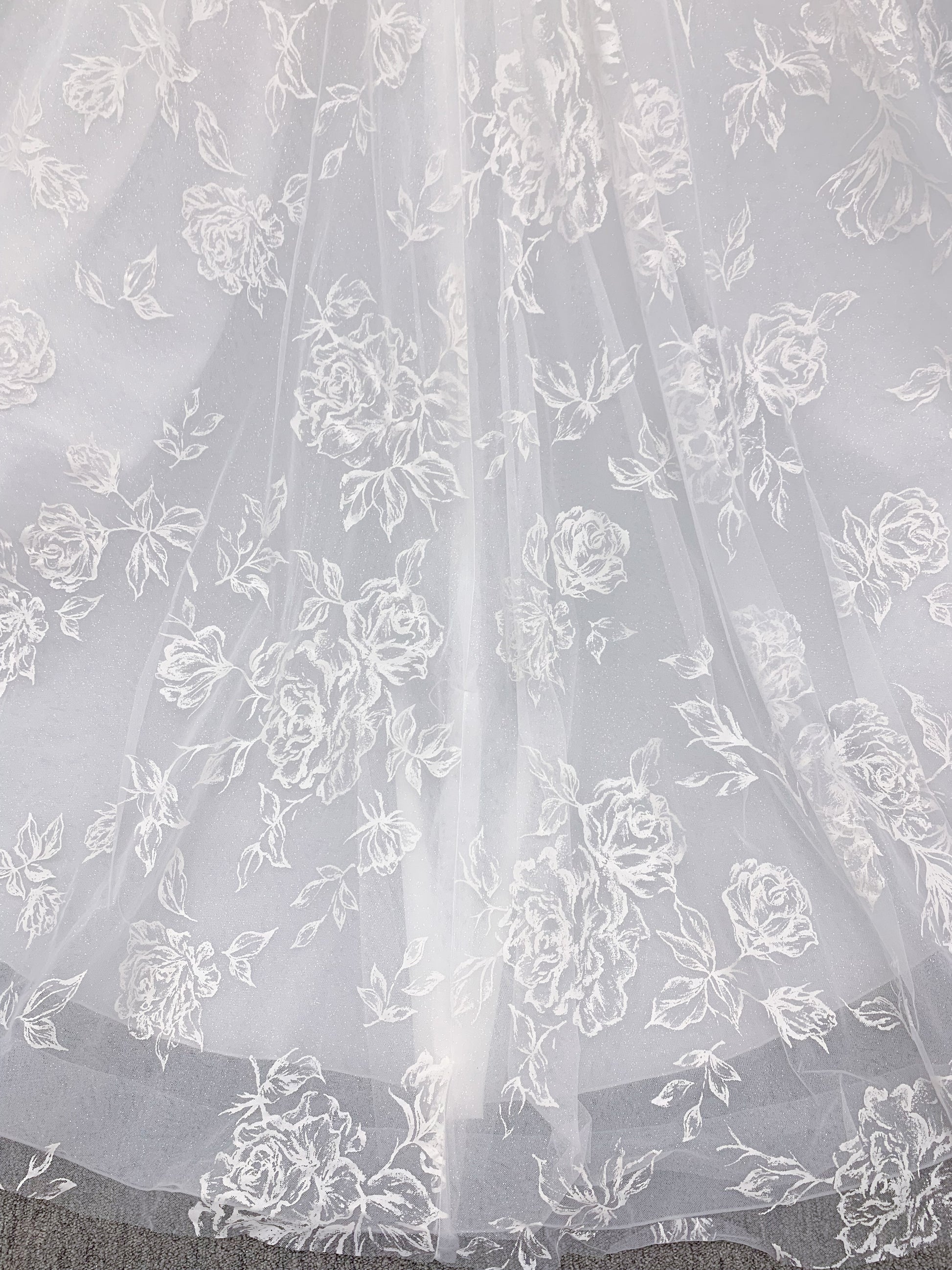 Morilee 2988 Rosie ball gown wedding dress in rose-printed organza over glitter tulle with V-neck, thin straps, structured boning, and voluminous sweeping train.